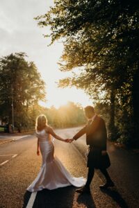The bride and groom hold hands