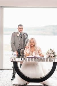 Kelsey and Dylan sign their marriage certificate in the ceremony space